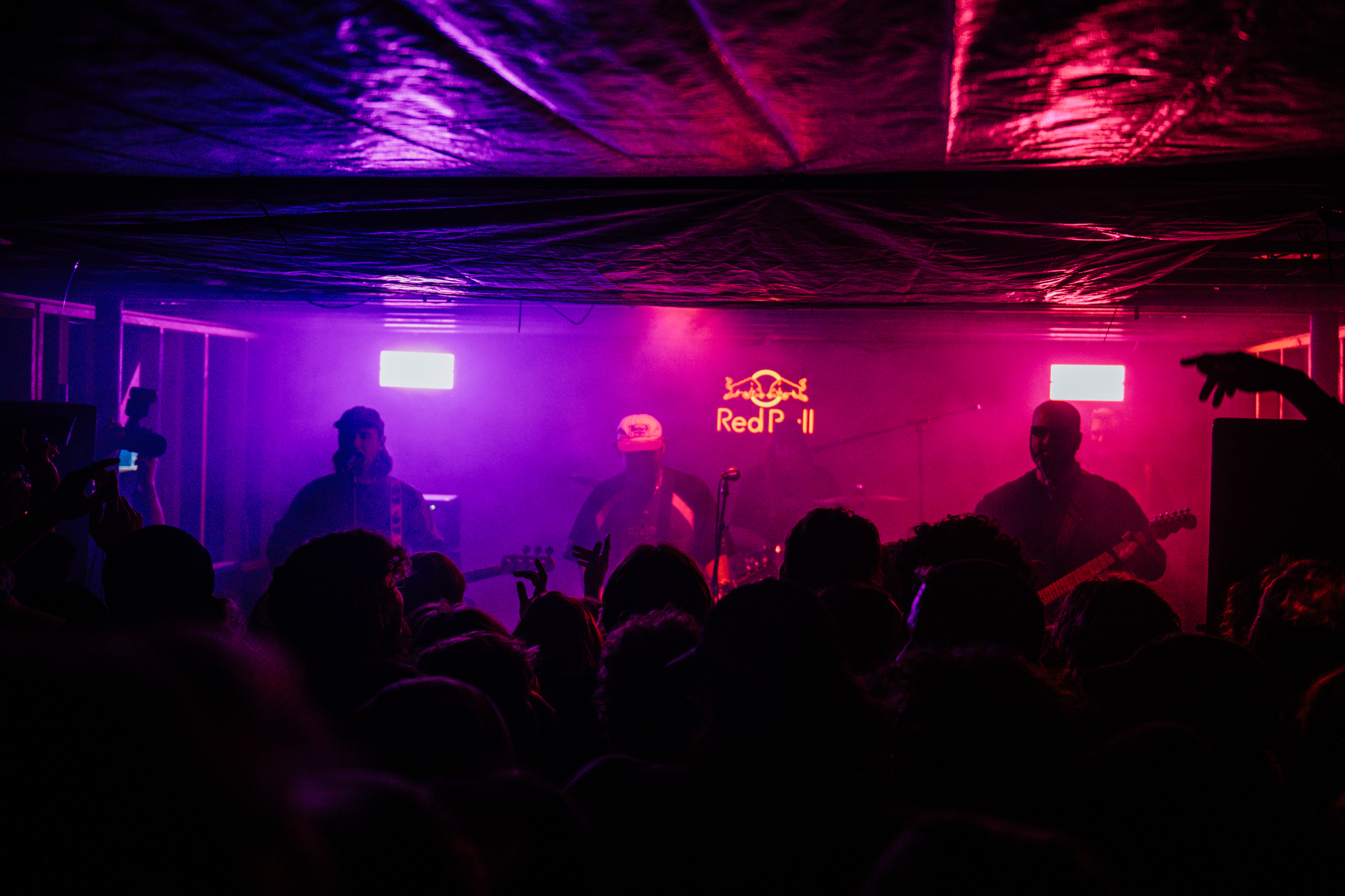 Live band performing on stage with purple and pink lighting at a TAS DJ Hire event